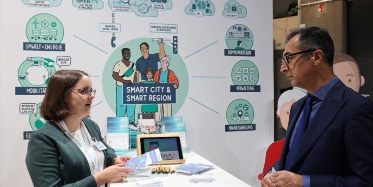 Chem Özdemir und unsere Kollegin Anne-Marie Kilpert im Gespräch vor unserem Smart City Stand auf der Messe.