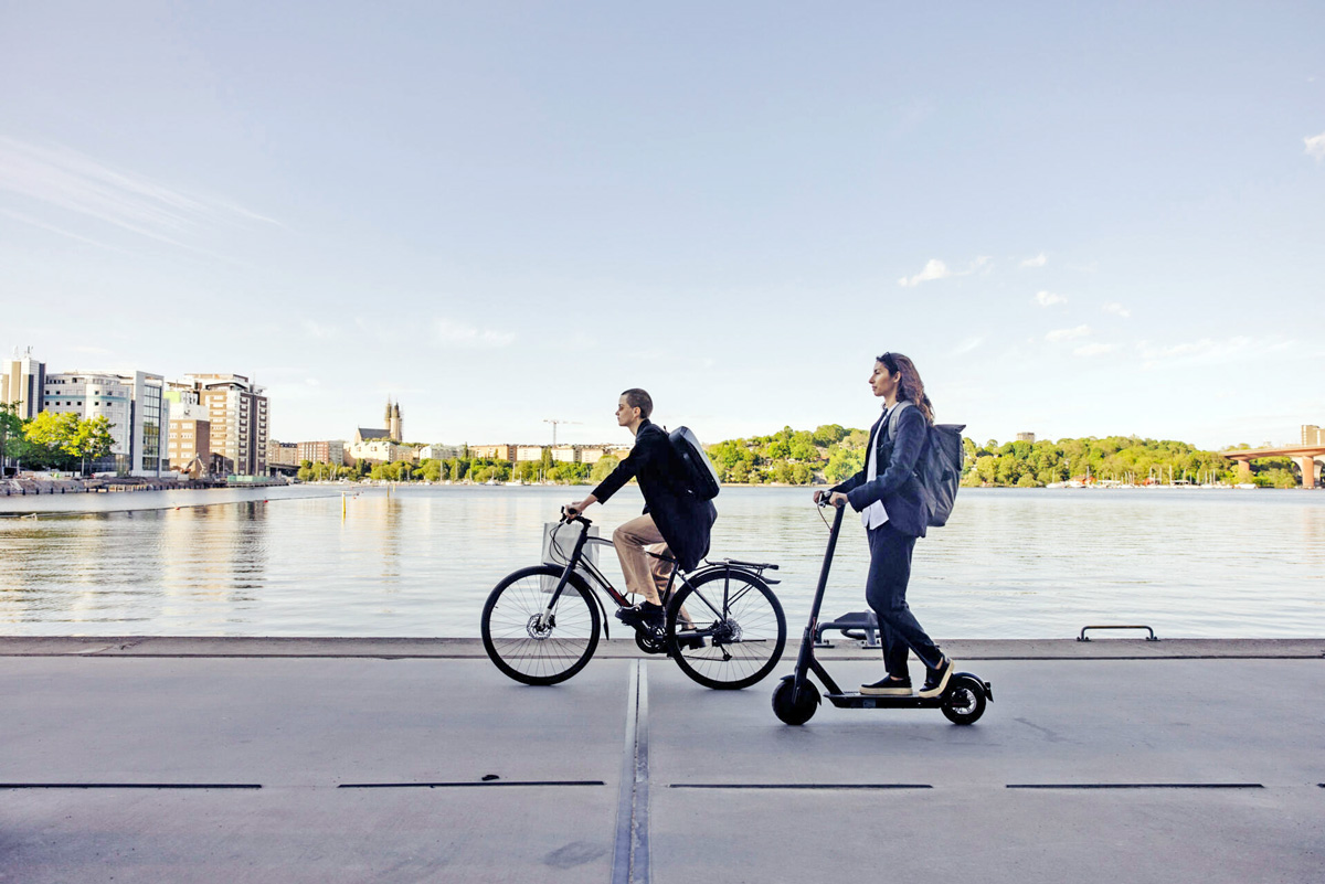 Nachhaltiges Wohnen. Pendeln in der Stadt zwischen Wohnort und Büro mit Fahrrad oder E-Roller.
